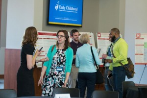 Faculty and graduate students discuss research posters.