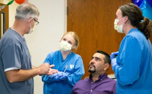 From left, Dr. Charles Craft and Nebraska College of Dentistry students Olivia Straka and Maddi McConnaughhay chat with patient  Manuel Hernandez.