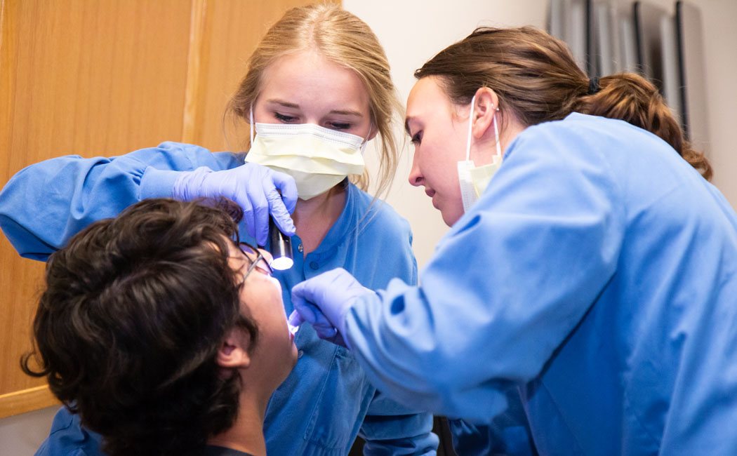 Patient Oscar Kaled Gonzales gets a checkup from Nebraska College of Dentistry students Olivia Straka and Maddi McConnaughhay at Lincoln's El Centro de las Americas.