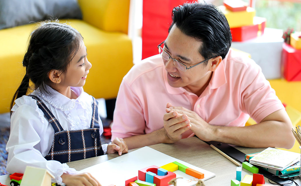 Parent and little child having fun playing educational toys