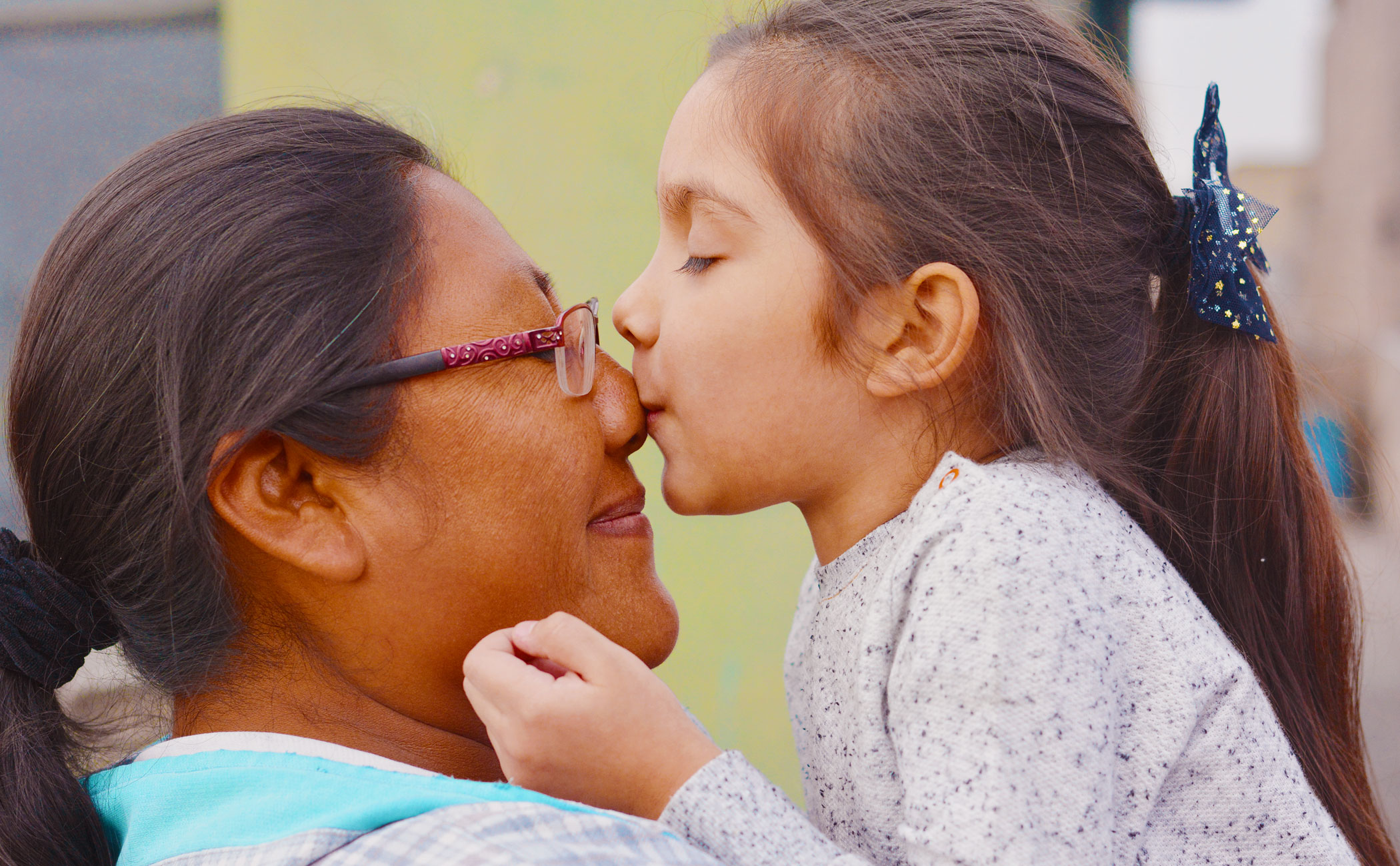 Native woman kissing child