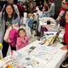 Jemalyn Griffin (right), associate professor of practice in advertising and public relations at the University of Nebraska–Lincoln, talks with a family about Nurture Nebraska at the Lincoln Airport's LNK Santa Bash community event Dec. 5, 2025.