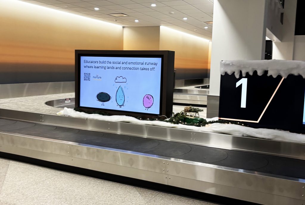 Nurture Nebraska digital signage in Lincoln Airport baggage claim area.