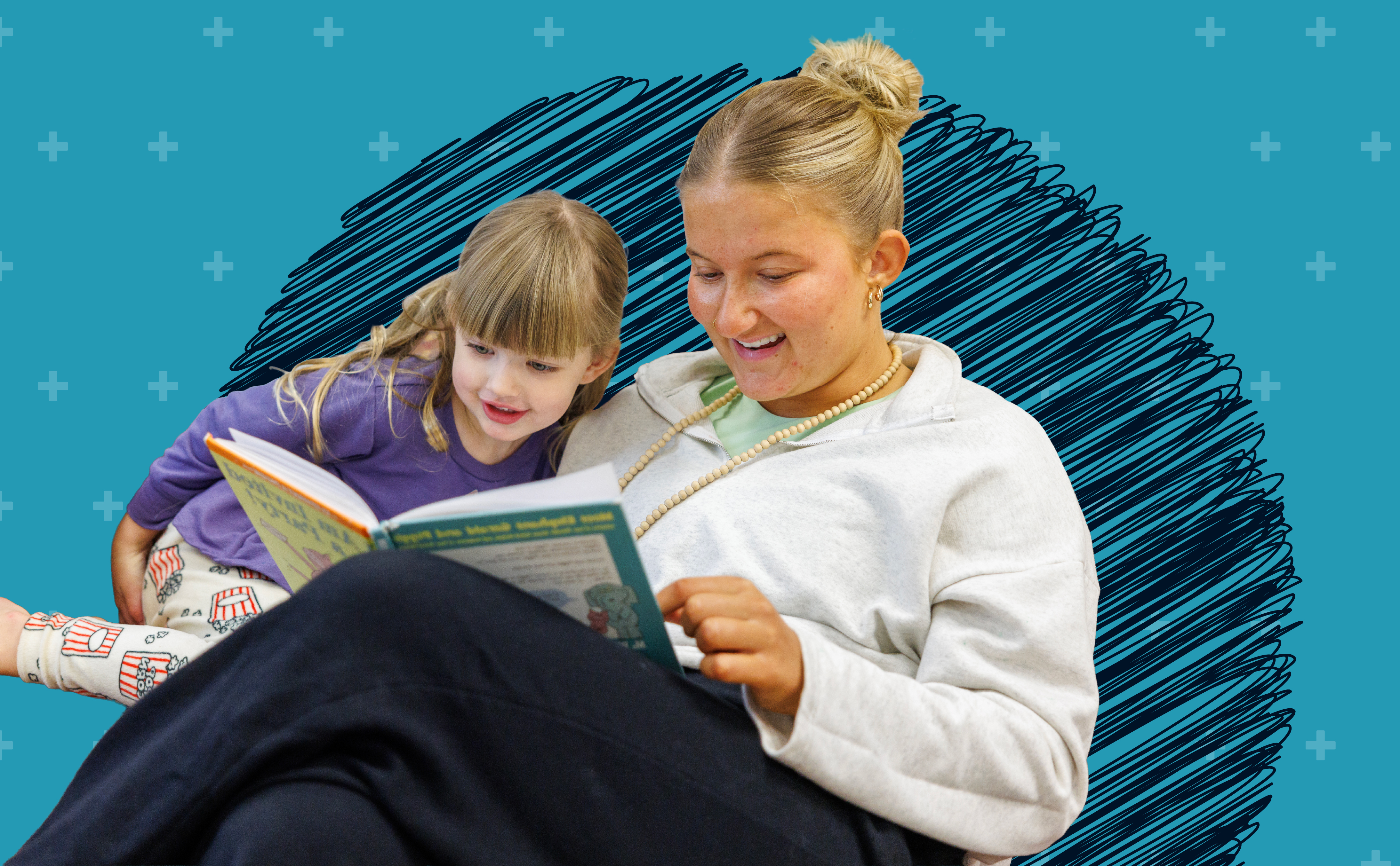 Young woman sitting and reading with preschool aged girl.