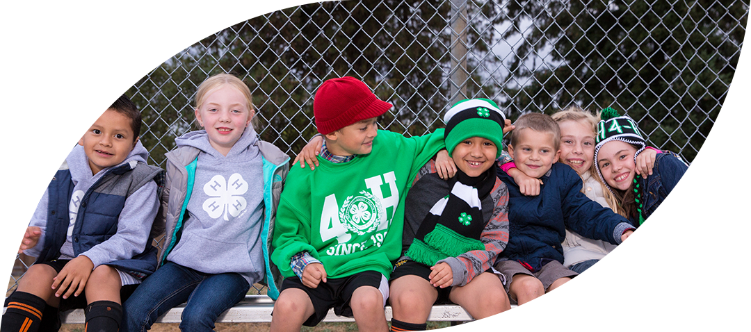 Group of 4-H Kids sitting together in the bleachers.